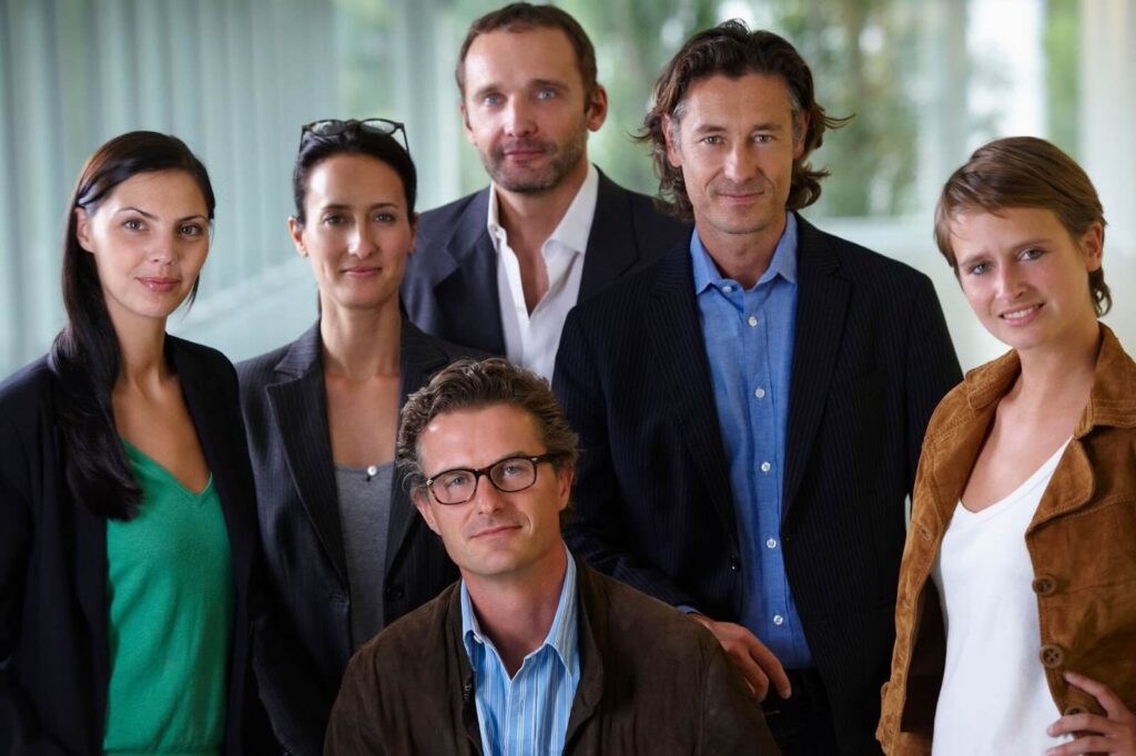 A group of people smiling for a business team photoshoot.